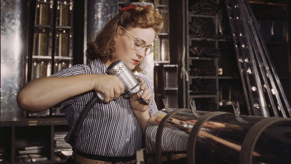 Woman using air drill on aircraft part in factory (Library of Congress/Alfred T. Palmer)